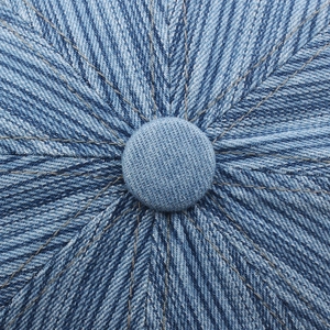 Top view of blue denim newsboy cap showing central button and radial stitching detail