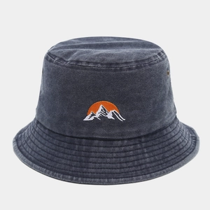 Detail of sunrise embroidery and metal eyelets on washed denim bucket hat