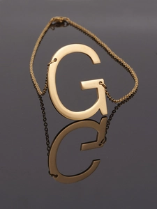 Detailed view of an 18K gold stainless steel necklace with a capital letter G pendant