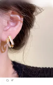 Detail of double-layer gold rectangle earrings with mother-of-pearl and pavé zircons
