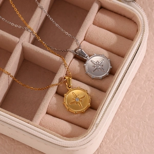 Detail of gold and silver north star necklaces with zircons in a jewelry box