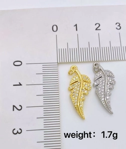 Detail of gold and silver feather pendants with cubic zirconia, weighing 1.7g and 2.5cm long