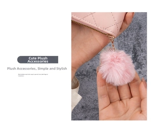 Dettaglio del portamonete trapuntato rosa con pompon in peluche e cerniera dorata