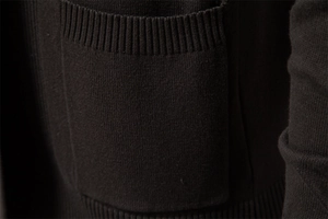 Detailed macro view of the knitted pocket edge on a premium men's cardigan sweater