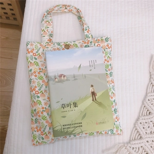 Vue détaillée du sac cabas floral en coton avec bouton pression près d'un livre