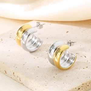 Détail de boucles d'oreilles créoles en C bicolores or et argent en acier titane
