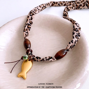 Retro necklace with leopard print fabric cord, wood beads and gold fish pendant