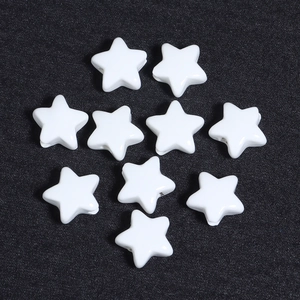 Macro detail of white ceramic star-shaped beads for DIY jewelry making on dark background