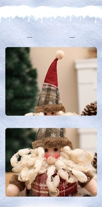 Detail of Santa plush toy with red plaid hat, curly white beard, and snowflake pattern