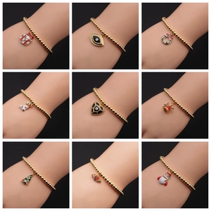Collage of gold-plated bead bracelets featuring Christmas charms and evil eye pendants