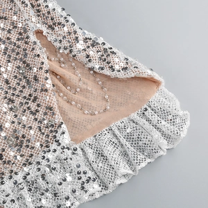 Close-up of silver sequins with white lace trim and pearl bead accents on mesh fabric