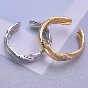 Macro shot of minimalist twisted texture rings in polished gold and silver finishes
