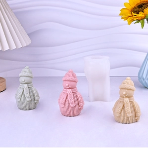 Detail of translucent silicone mold with knitted snowman candle models in pastel colors