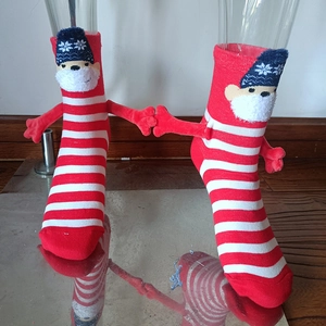 Detail view of 3D little hand design and cartoon character on striped Christmas socks