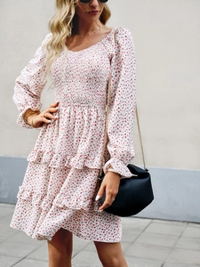Detail view of the floral white mini dress featuring smocked bodice and layered ruffle hem