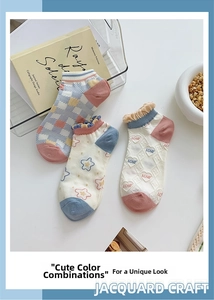 Close-up of three pairs of purple cotton socks with floral lace trim and jacquard patterns