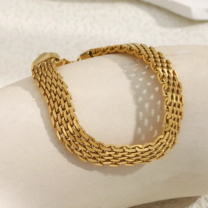 Detail of 18K gold plated stainless steel mesh watch band bracelet on display stand