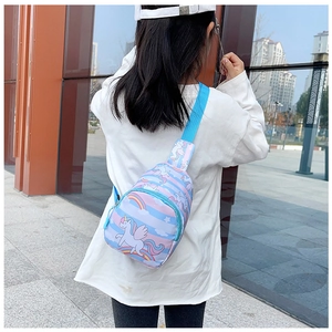 Girl wearing unicorn chest bag with rainbow pattern and blue adjustable strap