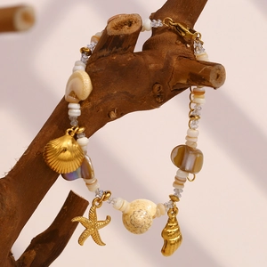 18K gold plated ocean charm bracelet with starfish and seashells on a natural branch