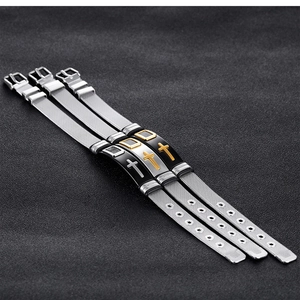 Detail of mesh strap bracelets with cross charms and adjustable buckles in three metallic tones