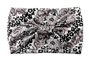 Close-up of a knotted wide headband featuring black and white floral and leopard patterns
