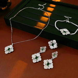Silver flower jewelry set with emerald green zircon crystals including necklace and ring