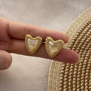 French vintage gold heart earrings with pearl inlay on soft white faux fur background
