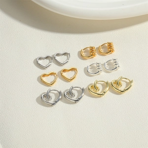 Close-up of gold and silver heart-shaped vintage earrings set with textured designs