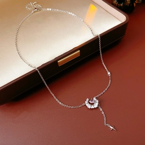 Détail du collier pendentif croissant de lune avec pierre rose et petite étoile sur cuir