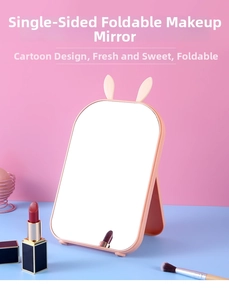 Detail view of pink foldable desk mirror with cute rabbit ears and stable support stand