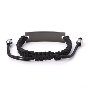 Detail of hand-woven black cord bracelet with smooth grey metal plate and adjustable slide