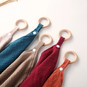 Detailed set of five cotton gauze baby comforter towels with natural wooden teething rings