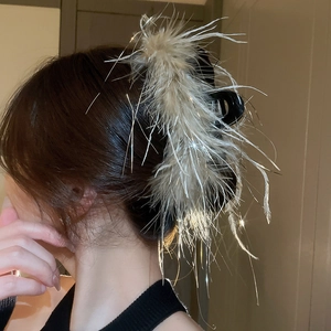 Detail of elegant hair claw clip featuring soft white feathers with shimmering accents