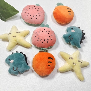 Close-up of plush fruit and dinosaur toys including watermelon, carrot and starfish