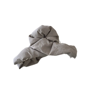 Grey pleated fabric claw clip for women, minimalist hair accessory on white background