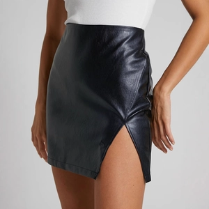 High-waisted black PU leather mini skirt with side slit detail worn by model