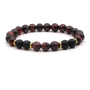 Detailed view of red tiger eye and matte black beads bracelet with golden metal spacers
