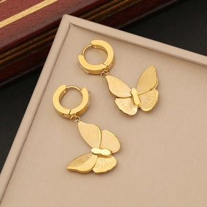 Detail of gold butterfly hoop earrings with cubic zirconias in a beige display box