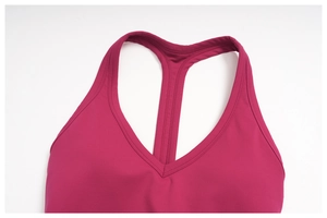 Detailed close-up of the Y-back design and stitching on a magenta yoga sports bra