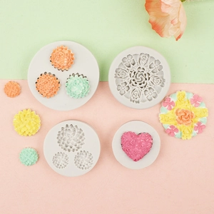 Detail view of flower and heart shaped silicone molds with colorful fondant cake decorations