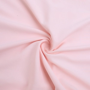 Détail du tissu rose doux présentant des plis en spirale et une texture délicate