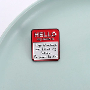 Enamel pin badge featuring Inigo Montoya name tag design on a ceramic plate