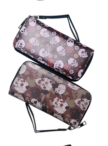 Detail view of large capacity wallets with skull patterns and wrist straps on white background