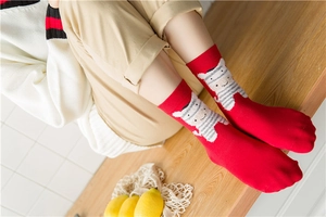 Detail of red festive feather yarn socks with cute cartoon zebra pattern and cotton texture