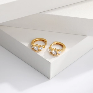 Close-up of golden S925 sterling silver hoop earrings with three inlaid zircon stones