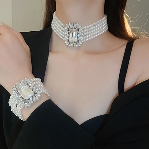 Detailed view of multi-layer pearl necklace and bracelet with zircon crystals