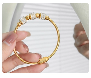 Detail of 18K gold-plated snake chain bracelet with sparkling crystal paved cylinders