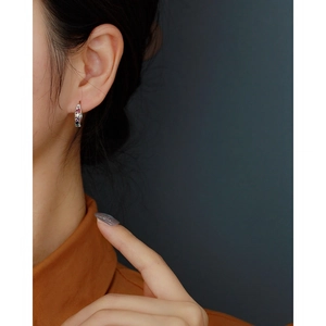 Close-up of 925 silver earring featuring vibrant multicolored zircon stones on model