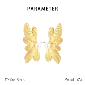 Detail view of gold butterfly wing earrings with white shell pearls and size 39x15mm