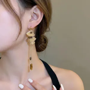 Ethnic style ginkgo leaf tassel earrings with tiger eye stone on elegant model